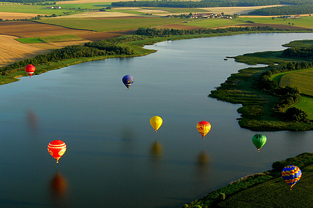 hot air balloons on body of water