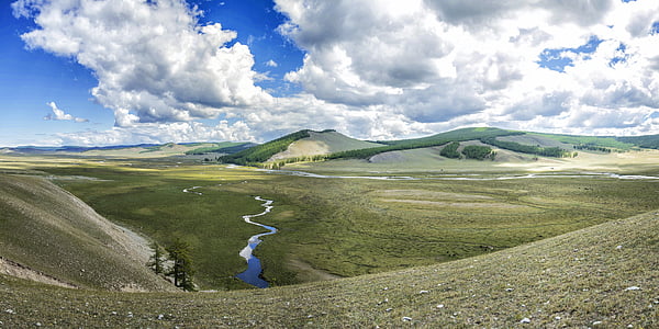 landscape photo of meadow with body of water in vicinity