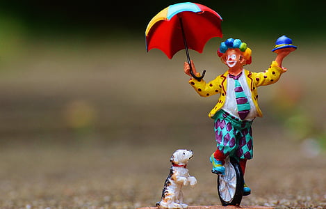 shallow focus photography of clown and dog figurines
