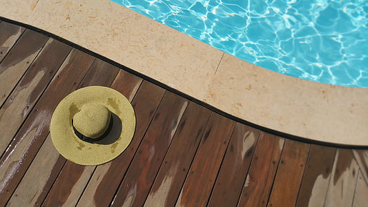 brown hat on brown wooden floor beside pool