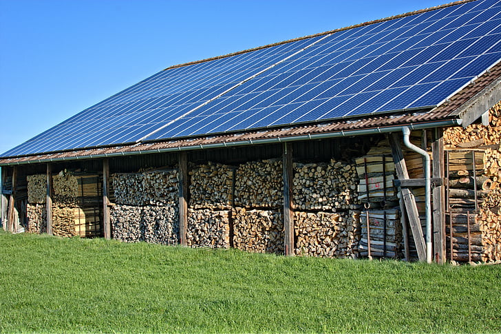 pile of brown lumbers above row of solar water panels