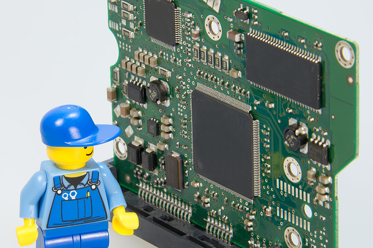 photo of blue LEGO character action figure looking at circuit board