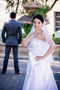 woman in white strapless wedding gown showing silence gesture