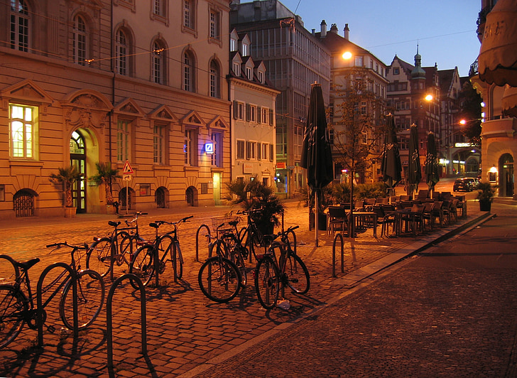 gray bicycles park near green patio umbrella during nighttime