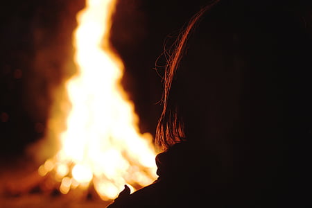 person facing bonfire