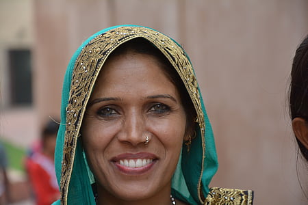 smiling woman wearing teal and brown floral cape