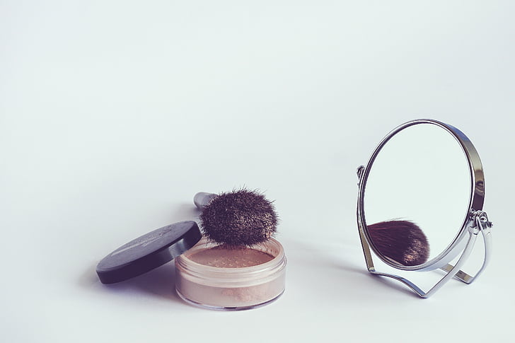 makeup brush beside vanity mirror