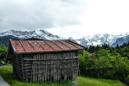 photo of gray wooden house near mountain and trees