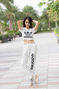 woman in white Adidas crop top and sweatpants posing for photo during daytime