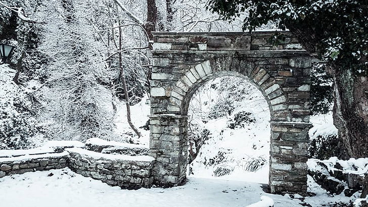 brown concrete arch gate covered with snow
