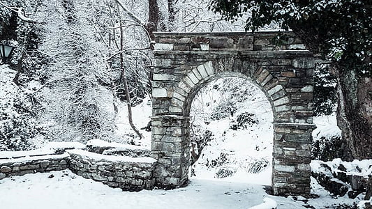 brown concrete arch gate covered with snow