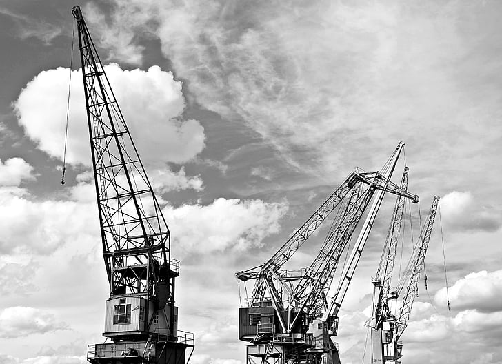 grayscale photography of industrial cranes
