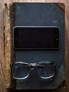 turned off space gray iPhone 6 beside eyeglasses on top of black books on table