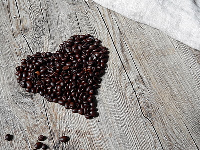 coffee beans formed into heart on gray surface