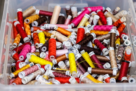 assorted-color threads on plastic container