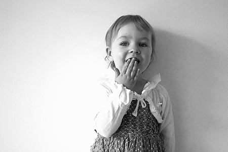 grayscale photography of a girl in long-sleeved dress white covering her mouth