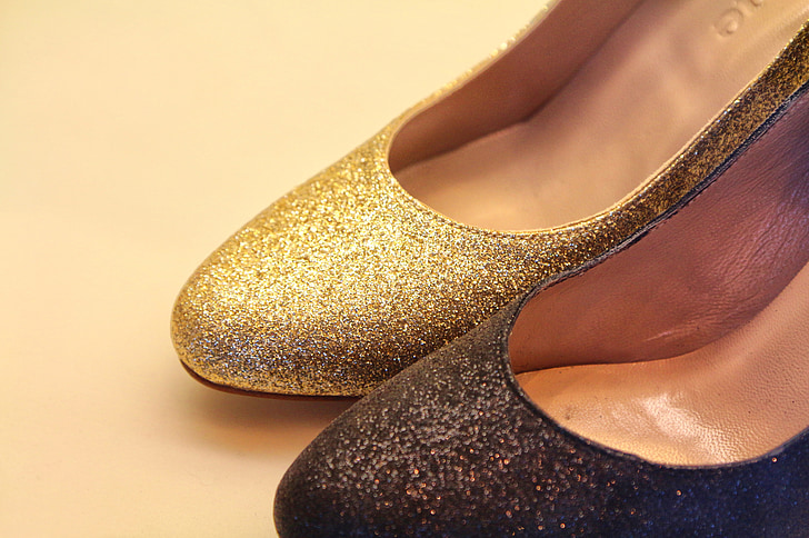 unpaired women's gold and black glittered shoes