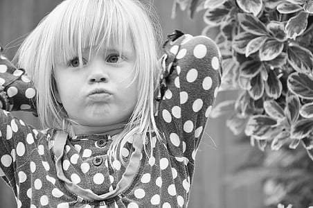 girl wearing black and white polka-dot clothes grayscale photo