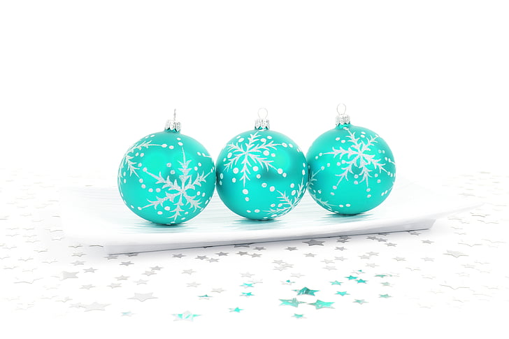 three teal Christmas baubles on white ceramic plate