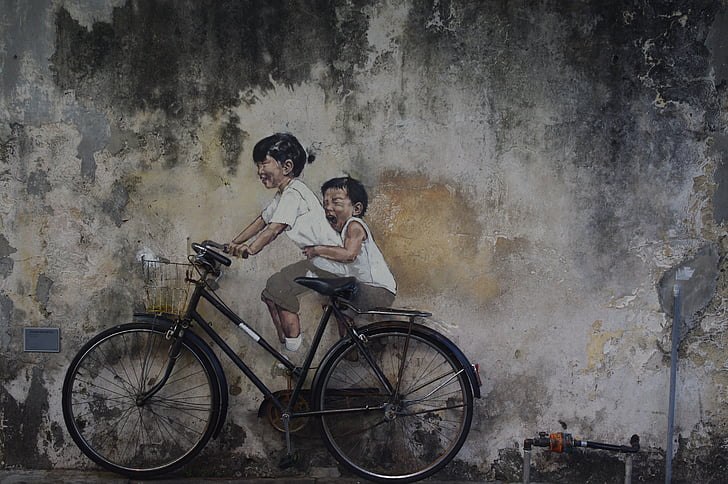 two children riding black city bike