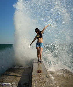 woman standing on breakwater during daytime