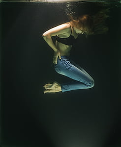 underwater photography of woman wearing black bra and blue denim jeans