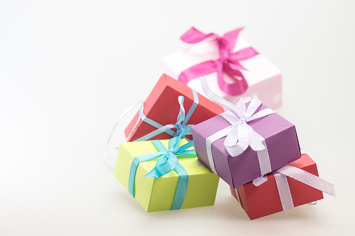 shallow focus photography of four assorted-color gift boxes