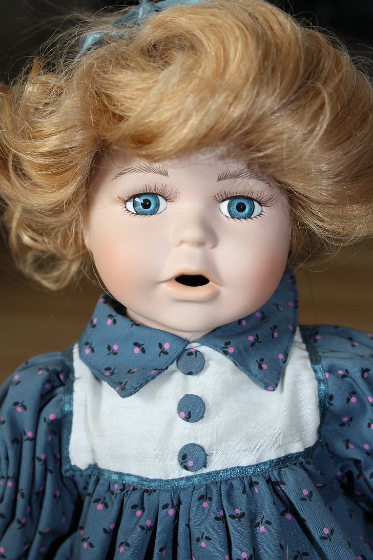 female doll wearing white and blue collared top