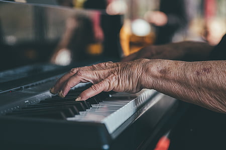 close up photo of person's hands playing black piano