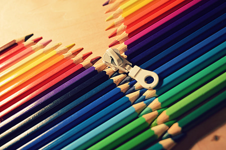 white zipper in between assorted-color pencils