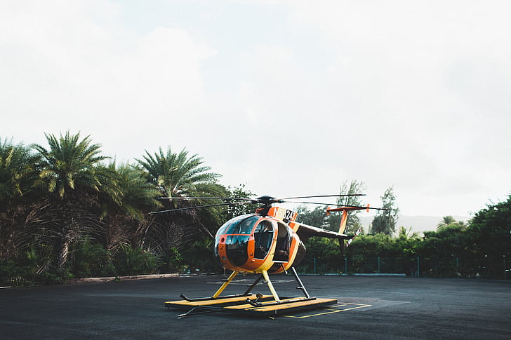 orange and black helicopter on land