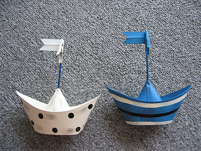 white and blue paper boats on gray textile