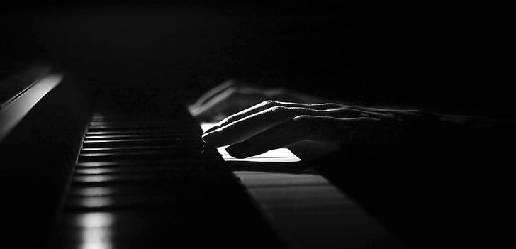 grayscale photography of person playing piano