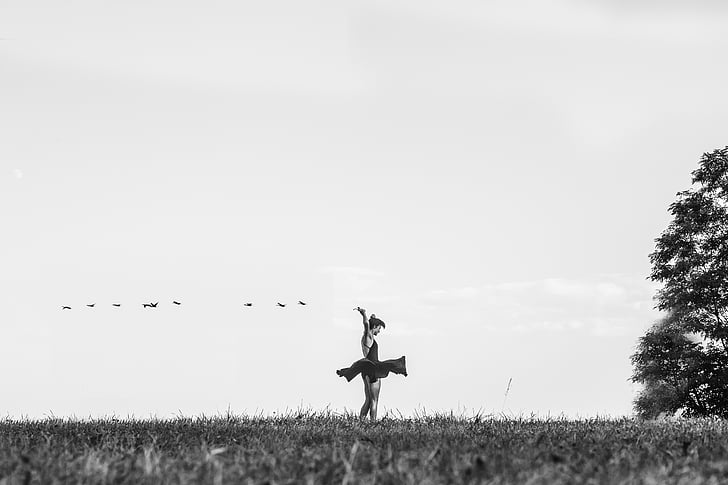 grayscale photo of woman dancing on lawn