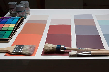 brown paint brush on white and orange paper