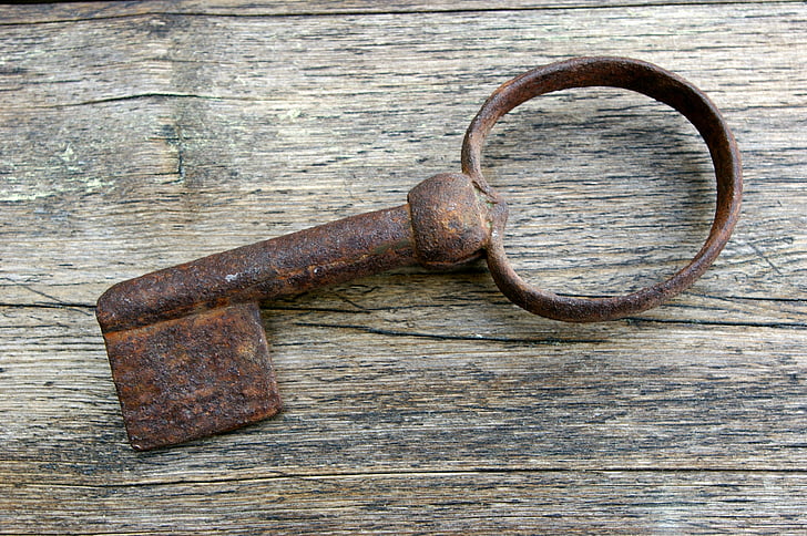 rusted brown skeleton key on brown wooden board