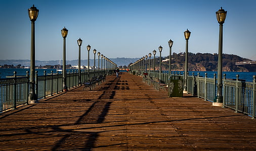 brown wooden pier with black lamp post on each side