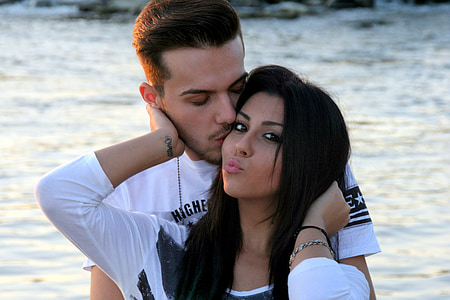 man kissing woman standing near body of water