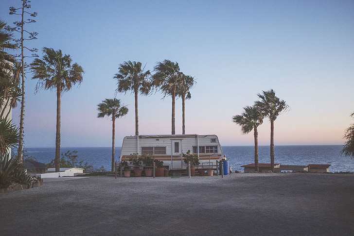 gray camper trailer near the ocean