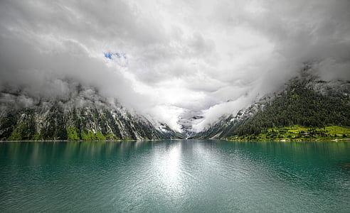 calm body of water in front of mountain