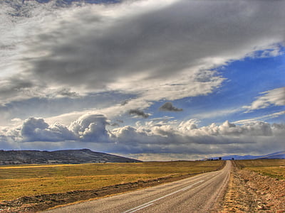 gray asphalt road under blue and white cloudy sky