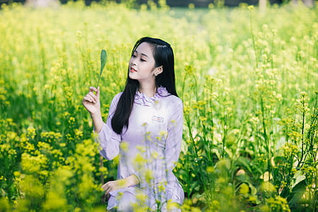 woman holding green leaf on green flower field