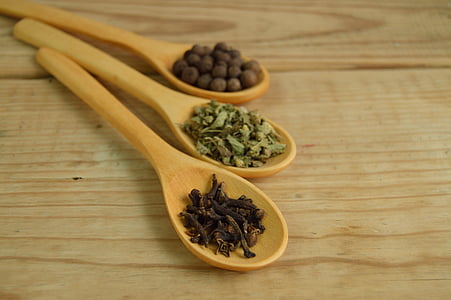 brown wooden ladles filled with herbs and spices