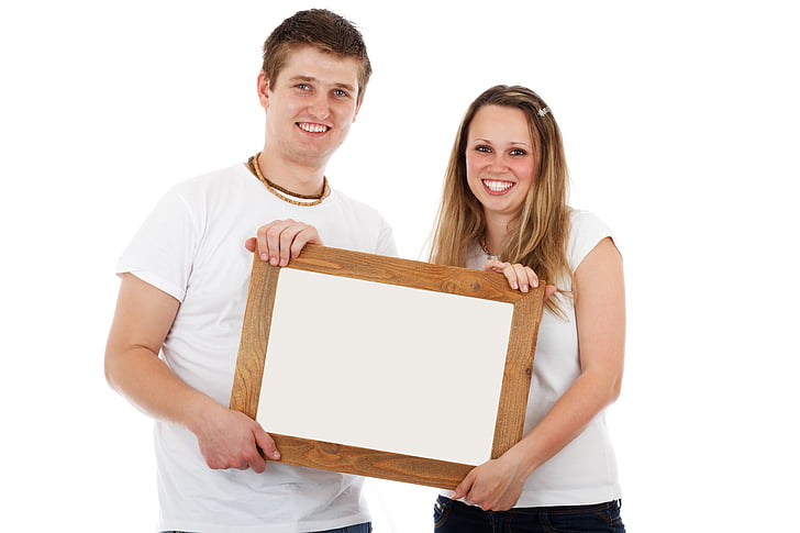 smiling woman and man holding wooden frame