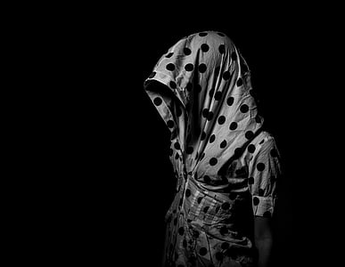 person wearing white and black polka-dot short-sleeved hooded shirt in dim light \
