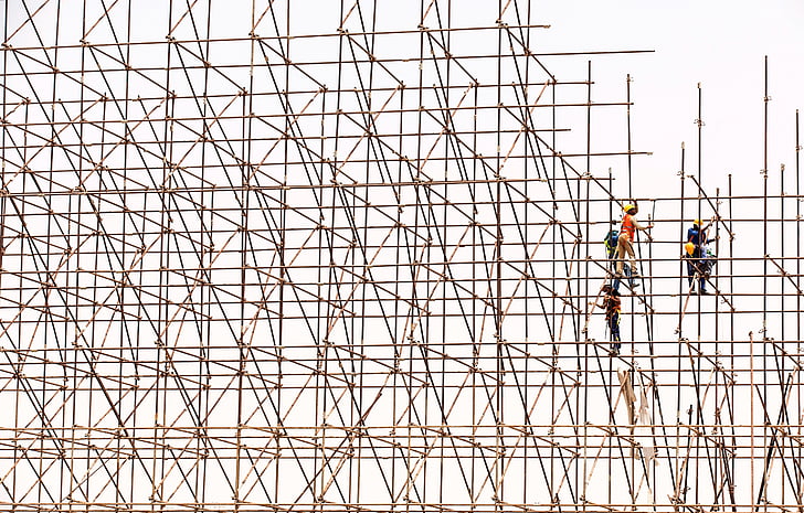 several men on bamboo scaffolding