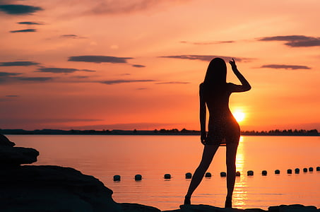 photo of woman's silhouette facing back during golden hour