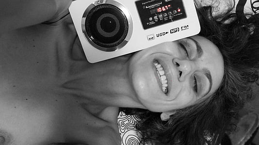 grayscale photography of woman smiling beside camera