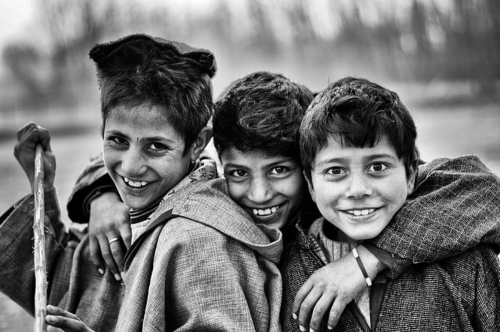 grayscale photo of three boys smiling