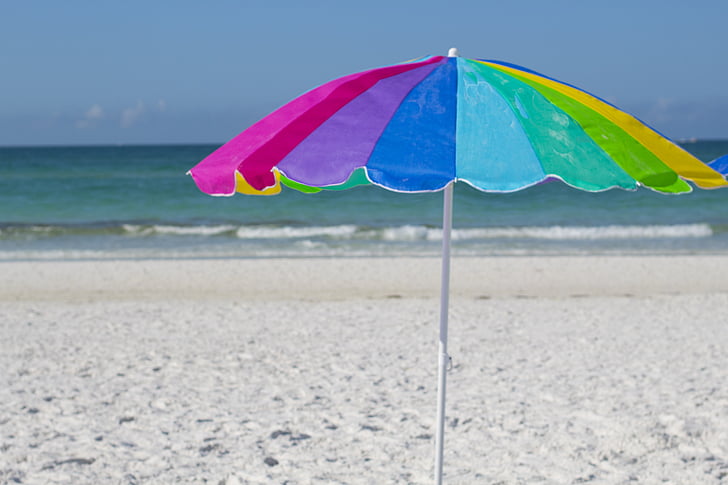 rainbow-colored umbrella on seashore